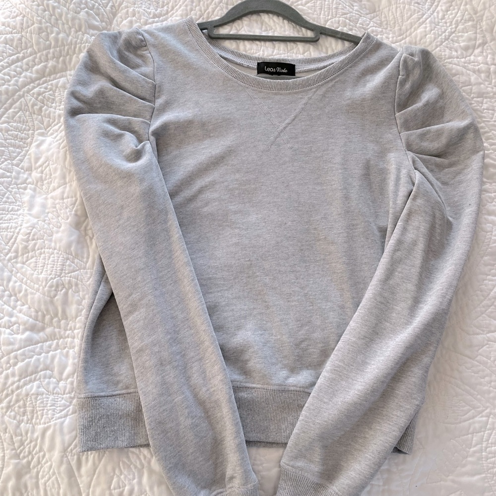 Grey sweatshirt with puff shoulders.